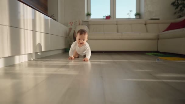 Lindo niño pequeño bebé feliz se arrastra en un piso de madera en casa. Concepto: vida, infancia, primer año de vida, paternidad, hogar — Vídeos de Stock