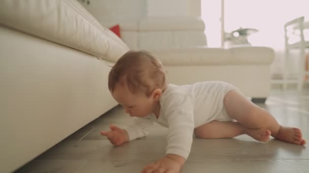 Pierwsze próby dziecka, aby wstać w pobliżu sofy. Pierwszy rok w życiu dziecka. rozwój dziecka — Wideo stockowe