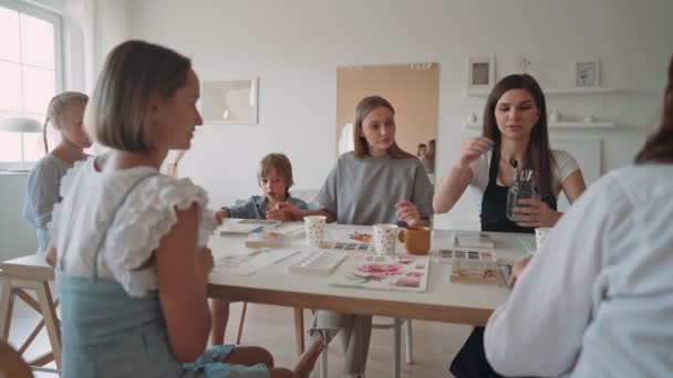 Konst skolan, kreativitet och människor koncept - grupp studenter med staffli, penslar och paletter målning stilleben på studio — Stockvideo