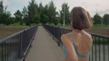 Köprünün ortasında koşan bir kadın. Arka plan çekimi. Bireysel başarı ve ün kavramı.