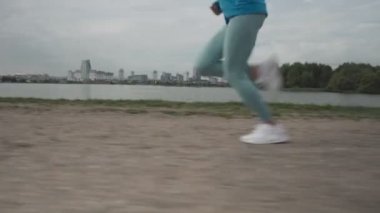 4K yakın mesafe koşu ayakkabısı giyen kadınlar yolda koşmaya başlıyorlar. Koşan kadınlar sahilde koşuyor. Kadın egzersizi sabah dışarıda koşuyor..