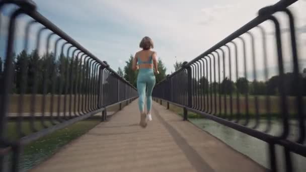 Woman running in the middle of the bridge. Background shot. Abstract concept of individual success and fame. — Stock Video