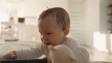 Sevimli bebek kanepeye yaslanmış ayağa kalkmayı öğreniyor. Sevimli çocuk kanepeye tutunmayı öğreniyor.