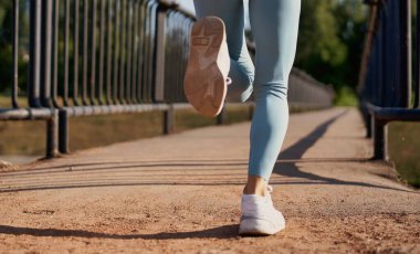 Güzel bayan koşucu sabah köprüde koşuyor..