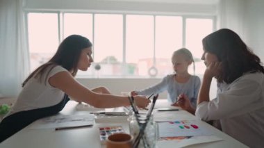 Genç beyaz anne ve küçük kızı birlikte resim dersi alıyorlar. Boya fırçası ve renkli akrilik boyalarla tuvale resim yapmak. Rahatlatıcı bir öğleden sonra..