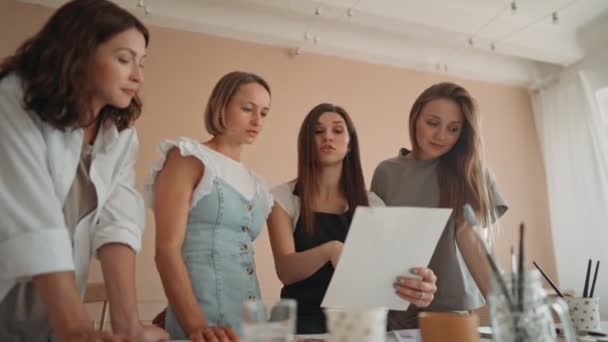 Frontansicht von vier schönen kaukasischen Frauen beim Kunstworkshop. Ein junger Lehrer unterrichtet Zeichnen — Stockvideo