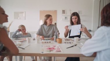 Mutlu anne ve kız çizim dersinde eğleniyor. Yaratıcı aile sanat stüdyosunda vakit geçiriyor. Atölyede çizim yapan kadın sanatçı.