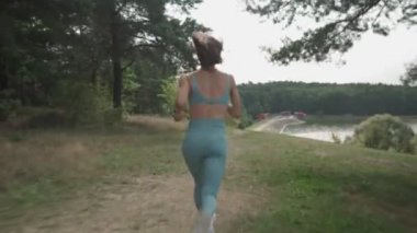 Ormanda yokuş yukarı koşan bir kadının yan görüntüsü.