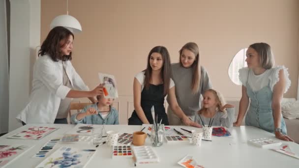 Gelukkige moeder en dochter genieten van de tekenles. Creatief gezin brengt tijd door in kunststudio. Vrouwelijke kunstenaar tekening in workshop. — Stockvideo