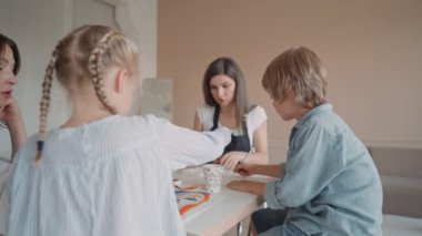 Mutlu anne ve kız çizim dersinde eğleniyor. Yaratıcı aile sanat stüdyosunda vakit geçiriyor. Atölyede çizim yapan kadın sanatçı.