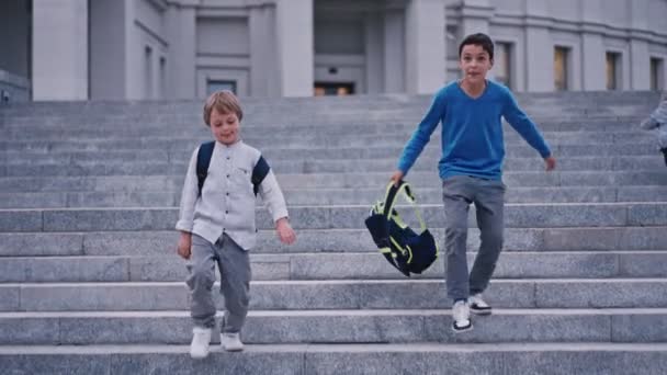 Movimiento lento de los niños de la escuela bajando de la escalera en la escuela 4k. — Vídeo de stock