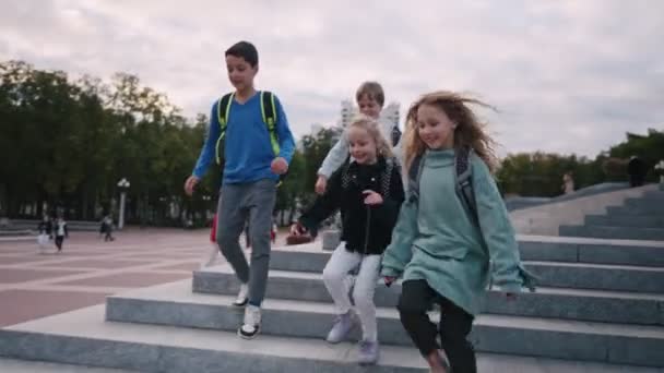 Glückliche Schulkinder rennen Steintreppen hinunter. Kinder gehen von der Schule — Stockvideo