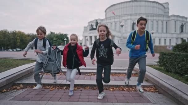 Šťastní školáci utíkají po kamenných schodech. Děti chodí ze školy. — Stock video