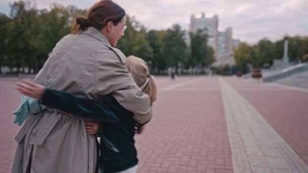 Mutter umarmt und küsst süßes Schulmädchen nach der Schule, Liebe und Bildungskonzept. — Stockvideo