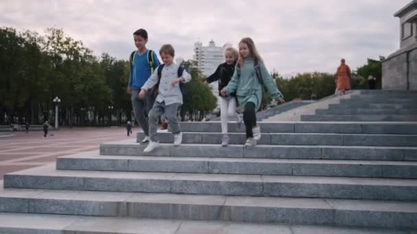 Niños de la escuela felices corren escaleras de piedra. Los niños van de la escuela — Vídeo de stock