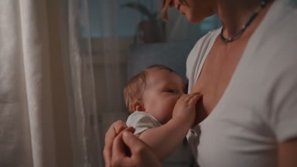 Giovane bella madre, che allatta il suo neonato di notte, luce fioca. Mamma allattamento infantile — Video Stock