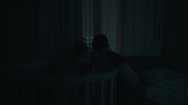 Nattfotografering av en mor som vaknar på natten till en gråtande bebis i barnsäng. Kaukasiska nyfödda Toddler hemma i Kids Bedroom. Begreppet barndom, nytt liv och föräldraskap — Stockvideo