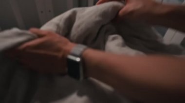 Sevimli yeni doğmuş erkek bebek, geceleri beşikte uyumak istemiyorum. Anne bebeği yatırır.