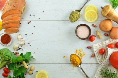 Tahta masadaki çeşitli baharat ve otların üst görüntüsü