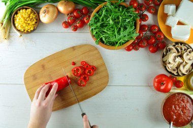Tahta masadaki taze sebzelerin ve malzemelerin üst görüntüsü.