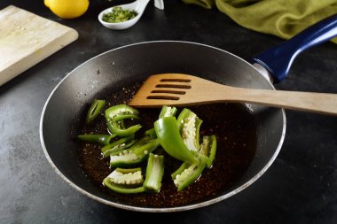 Frying pan with chili pepper on background, close up