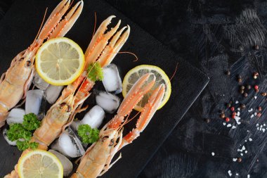 Buz ve Limonlu Kara Arkaplanda Çiğ Karidesler