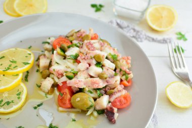 Arka planda dilimlenmiş portakallı ahtapot salatası, yakın plan.