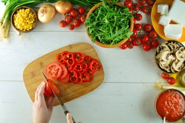 Tahta masadaki taze sebzelerin ve malzemelerin üst görüntüsü.