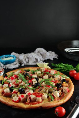 Arka planda lezzetli deniz ürünleri pizzası, yakın plan.