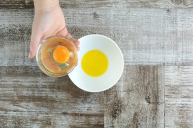 Gri ahşap arka planda beyaz kasede yumurta