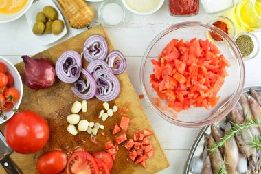 Ahşap bir masada taze mürekkep balığı ve yemek malzemeleri.