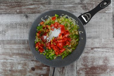 pan with vegetables   on wooden table,close up