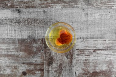 Tahta arka planda cam kasede yumurta ve baharat.