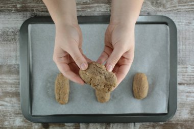 Kadın elleri ahşap bir masada yemek hazırlıyor.