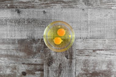 Ahşap arka planda cam bir kasede yumurtalar