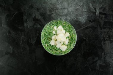 Siyah arka planda yeşil sos ve tereyağı. en üstteki görünüm.