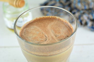 Tahta bir masanın üzerindeki bir fincan kahveyi kapat.