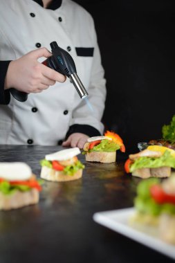 Şef arka planda tavuk kanepede ızgara yapıyor, kapat.