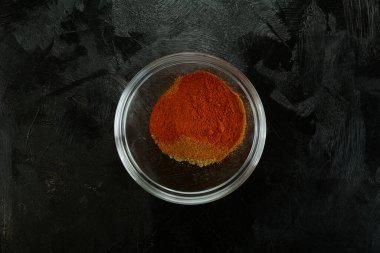 Siyah arka planda baharatlar olan bir kasenin üst görüntüsü