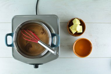 Ev yapımı çikolatayı ahşap masada pasta için hazırlama manzarası