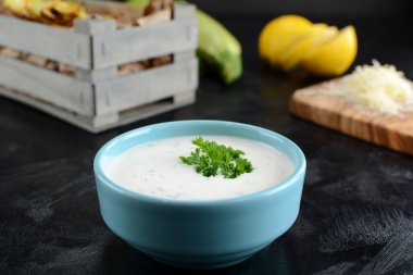 Arka plandaki kasede maydanozlu taze sos.