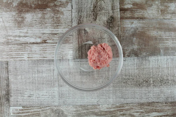 Ahşap arka planda bir kasede gruplandırılmış sığır eti.