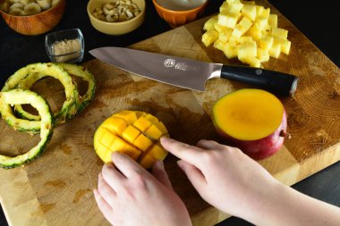 Ahşap tahtada mango meyvesi kesen kadın