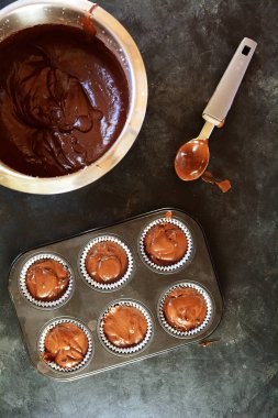 Siyah arka planda ev yapımı çikolatalı kekler hazırlıyorum.