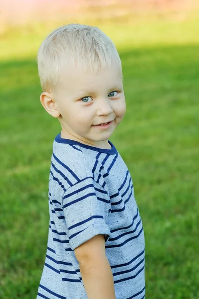 Портрет маленького светловолосого мальчика, улыбающегося на открытом воздухе — стоковое фото