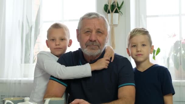 Портрет взрослого бородатого мужчины, обнимающего внуков. Концепция счастливой семьи — стоковое видео