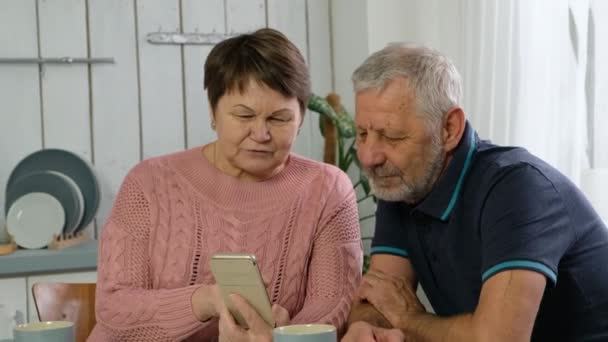 Coppia di anziani, uomo maturo e donna anziana guardando smartphone, videochiamata — Video Stock