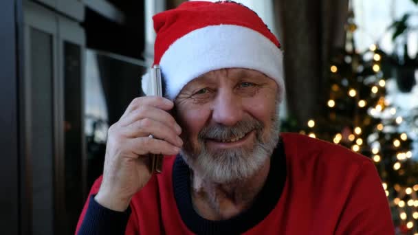 Feliz beared homem sênior em chapéu de Natal vermelho falando no telefone inteligente — Vídeo de Stock