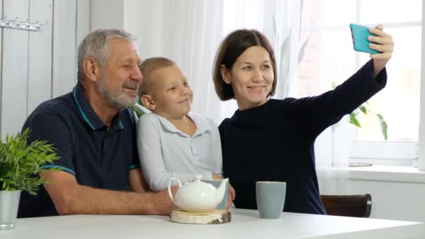 Szczęśliwy starszy mężczyzna z dorosłą córką i wnukiem robi selfie na smartfonie — Wideo stockowe