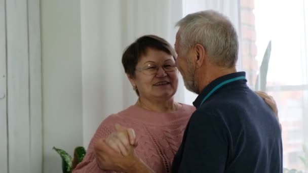 Старшая пара, зрелый мужчина и пожилая женщина танцуют на кухне — стоковое видео